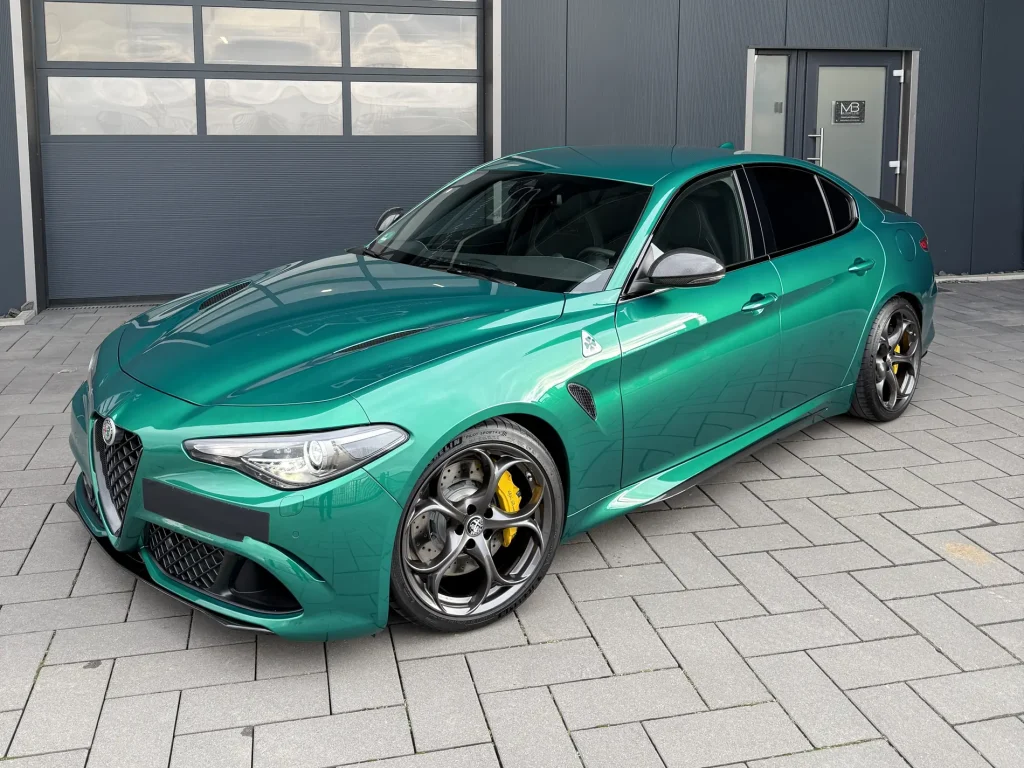 Alfa Romeo Giulia in Grün, Schrägansicht von vorn vor der Halle von MB Autopflege