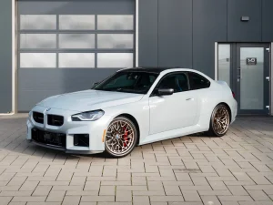 BMW M2 CS in Hellgrau, Schrägansicht von vorn vor der Halle von MB Autopflege