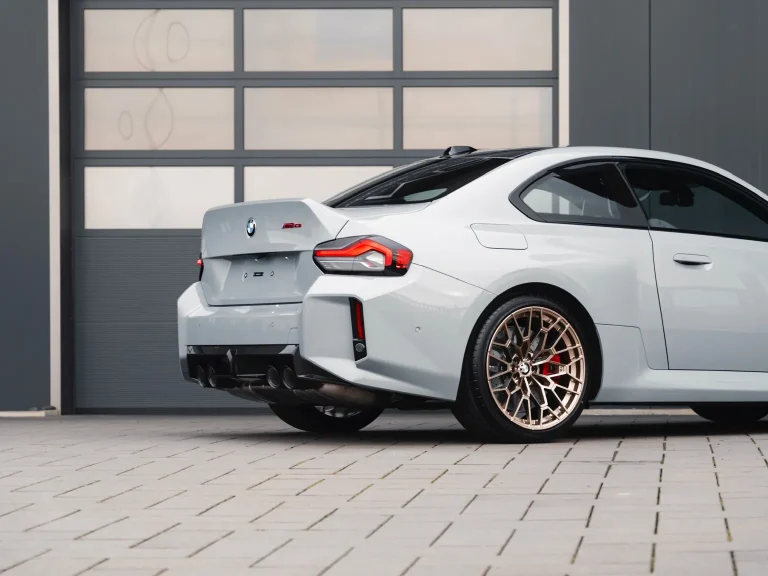 BMW M2 CS in Hellgrau, Schrägansicht von hinten vor der Halle von MB Autopflege