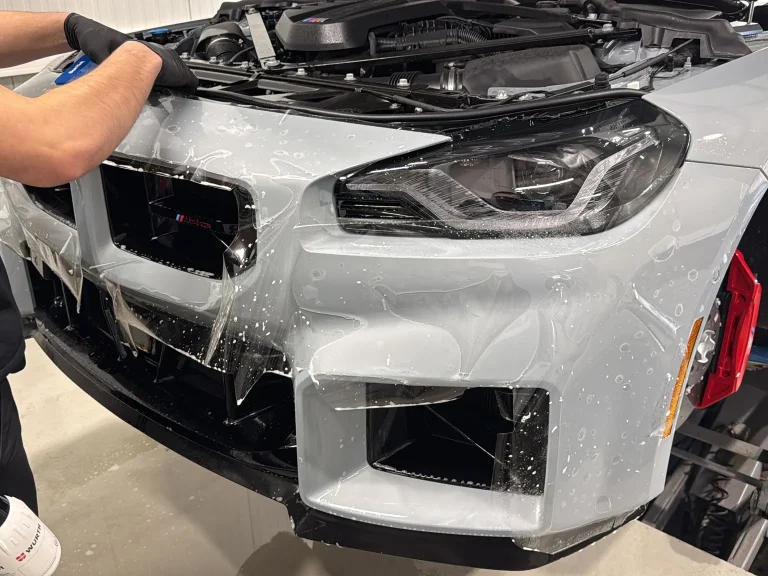 BMW M2 CS in Hellgrau, Lackschutzfolie wird an der Frontschürze angebracht