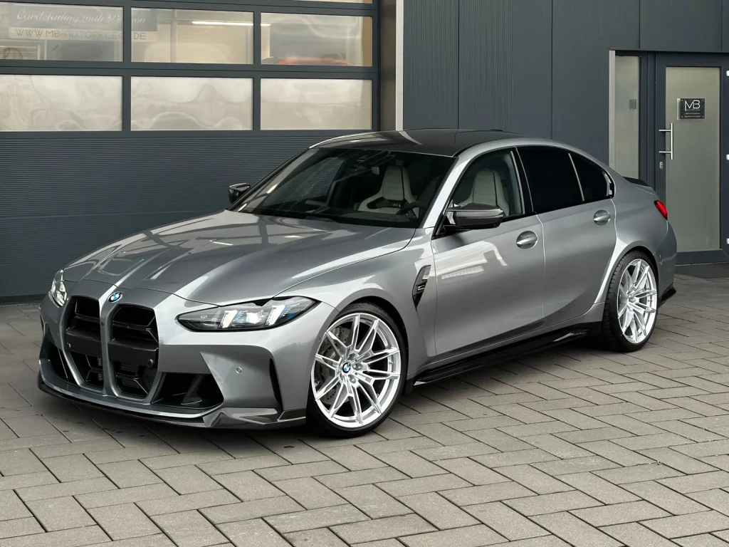 BMW M3 Competition in Grau, Schrägansicht von vorn vor der Halle von MB Autopflege