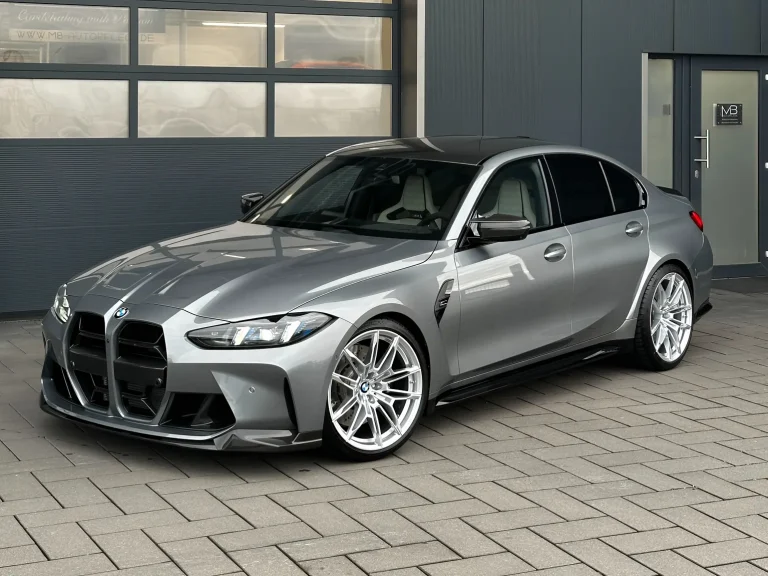 BMW M3 Competition in Grau, Schrägansicht von vorn vor der Halle von MB Autopflege