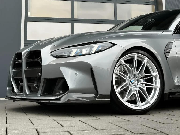 BMW M3 Competition in Grau, Front und Vorderrad in Nahaufnahme vor der Halle von MB Autopflege