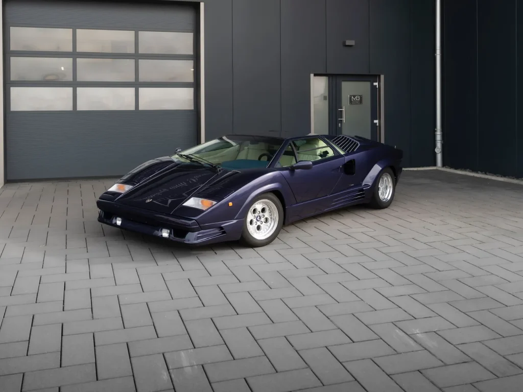 Lamborghini Countach in Violett, Schrägansicht von vorn vor der Halle von MB Autopflege