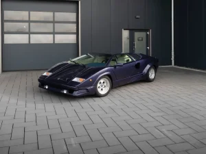 Lamborghini Countach in Violett, Schrägansicht von vorn vor der Halle von MB Autopflege