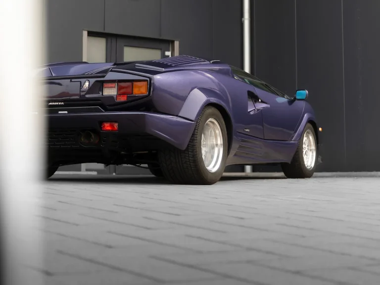 Lamborghini Countach in Violett, Schrägansicht von hinten vor der Halle von MB Autopflege
