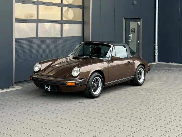 Porsche 911 3.0 in Braunmetallic, Schrägansicht von vorn vor der Halle von MB Autopflege