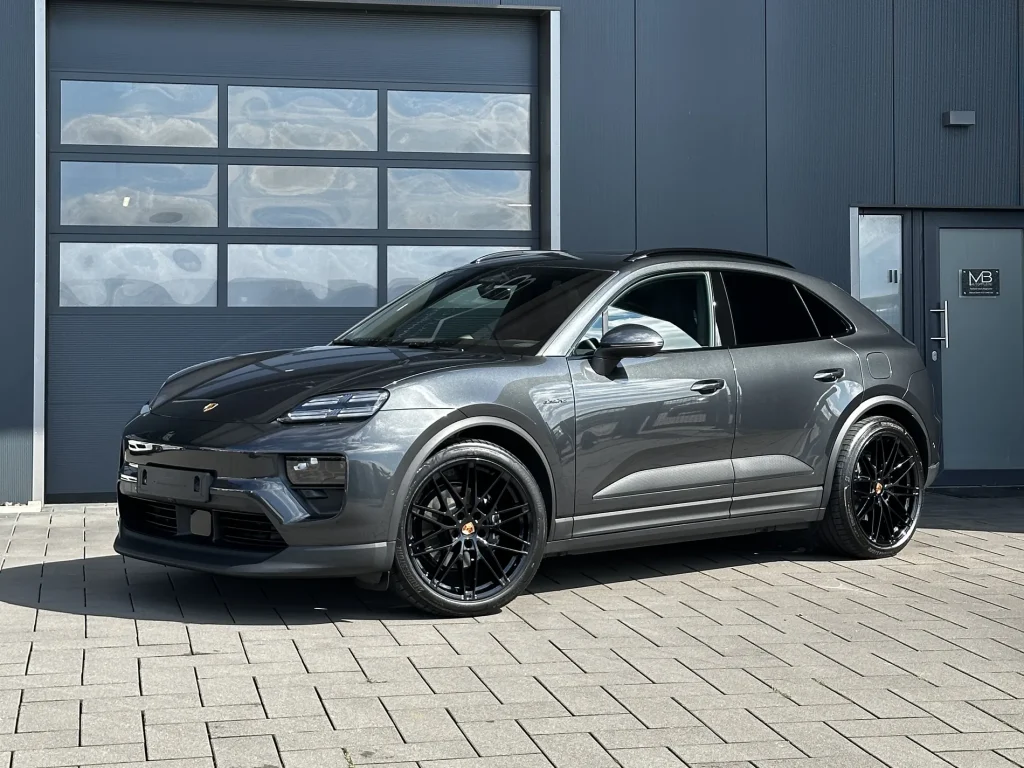 Porsche Macan in Dunkelgrau, Schrägansicht von vorn vor der Halle von MB Autopflege