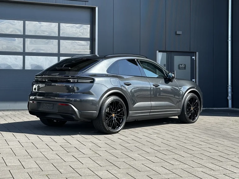 Porsche Macan in Dunkelgrau, Schrägansicht von hinten vor der Halle von MB Autopflege